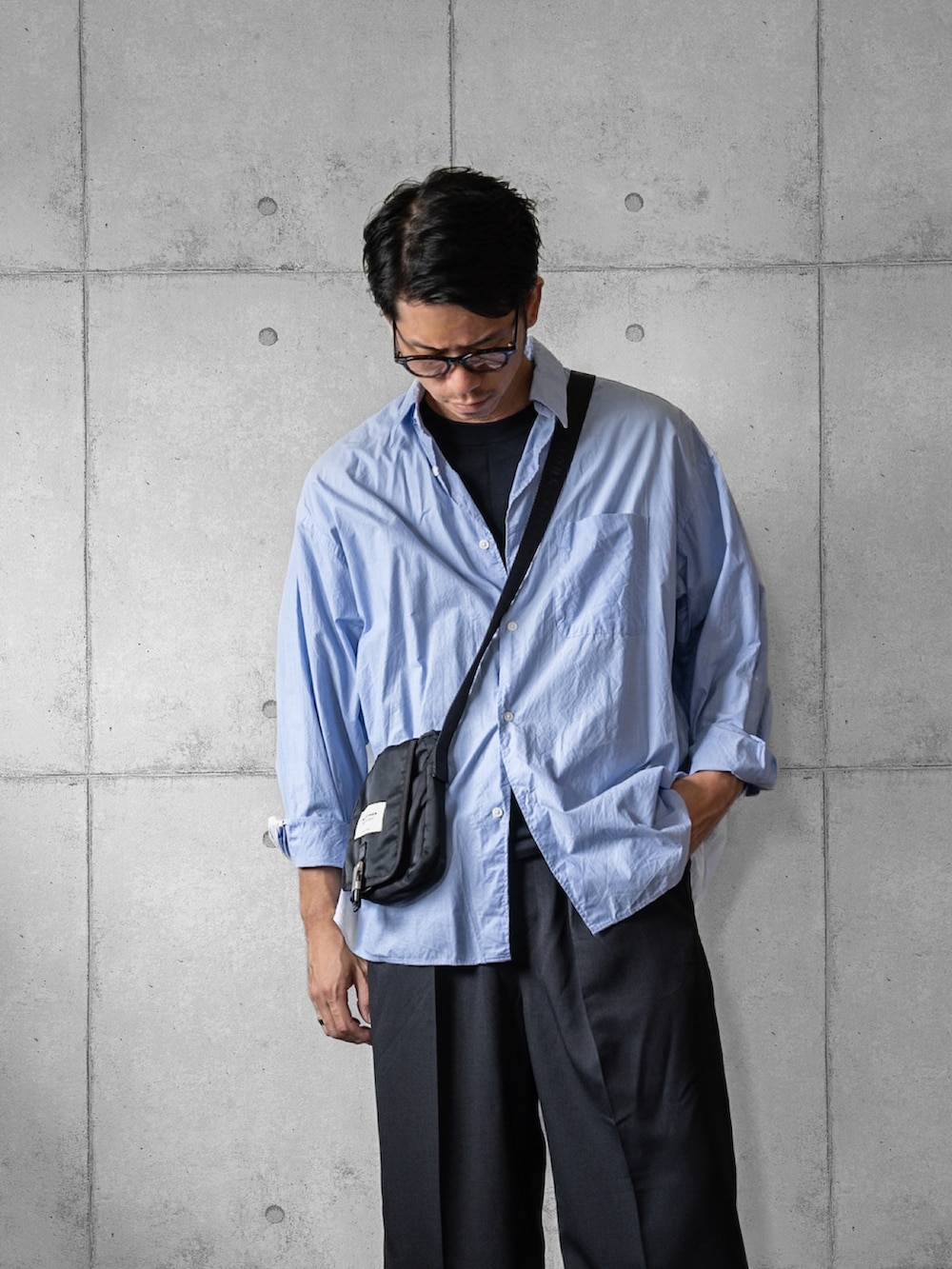 ブルー系のシャツ/ブラウス、ブラック系のスラックス、ホワイト系のスニーカーを着用したメンズの秋コーディネートの2枚目の写真