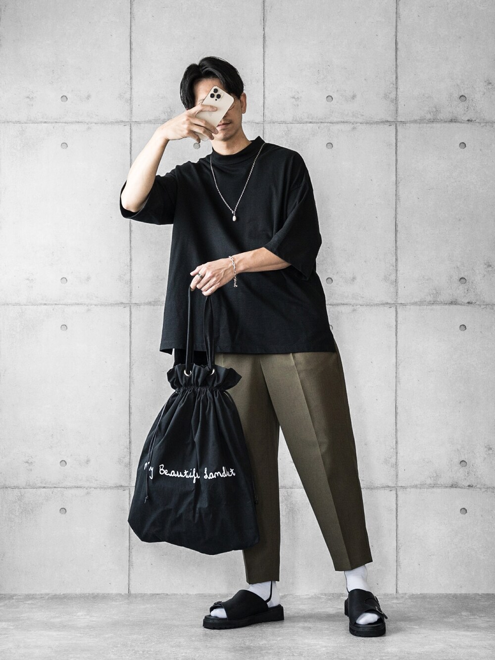 ブラック系のTシャツ/カットソー、グリーン系のパンツ、ブラック系のサンダルを着用したメンズの夏コーディネートの2枚目の写真