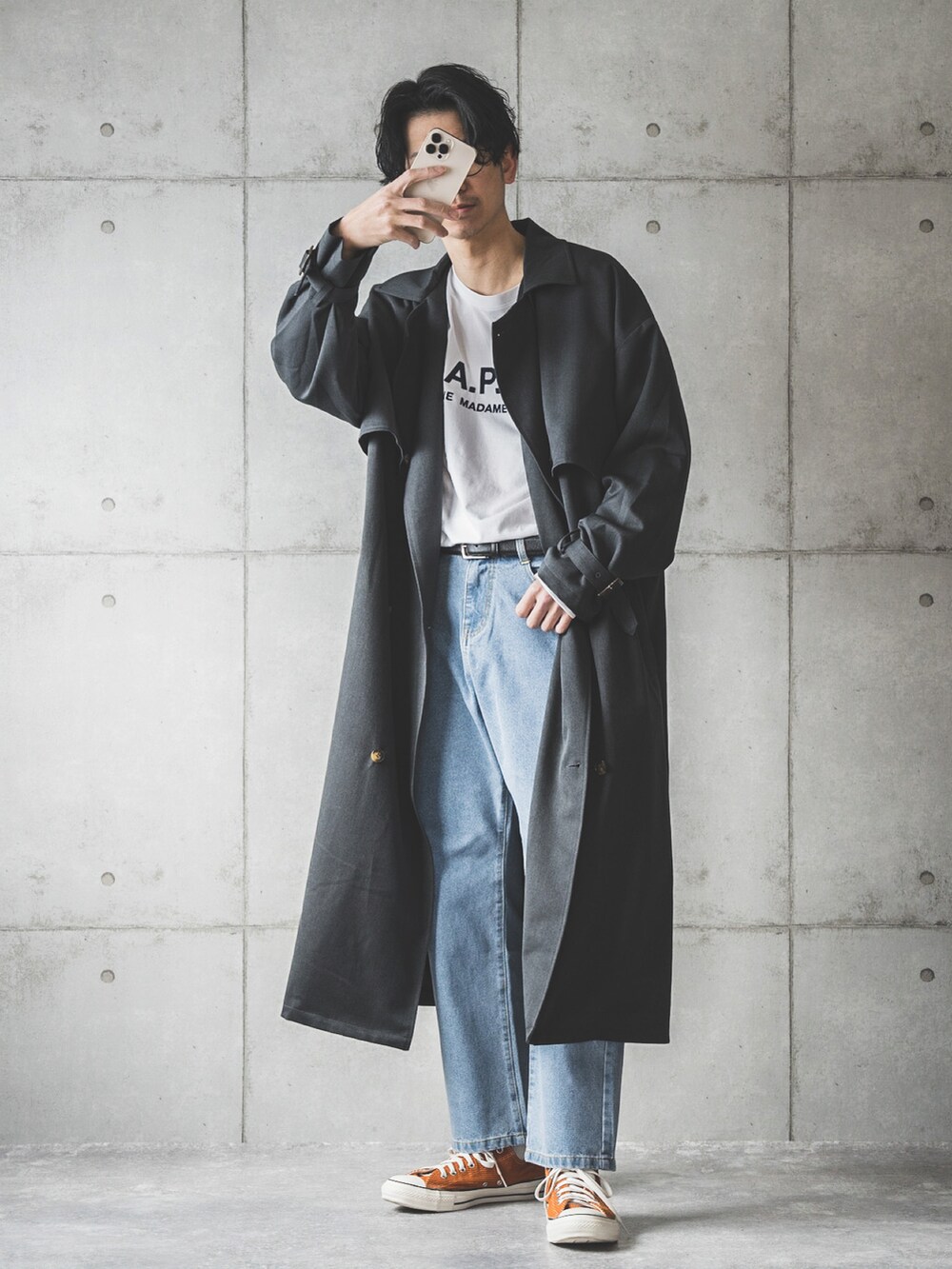 ブルー系のデニムパンツ、ホワイト系のTシャツ/カットソー、グレー系のトレンチコートを着用したメンズの冬コーディネートの2枚目の写真