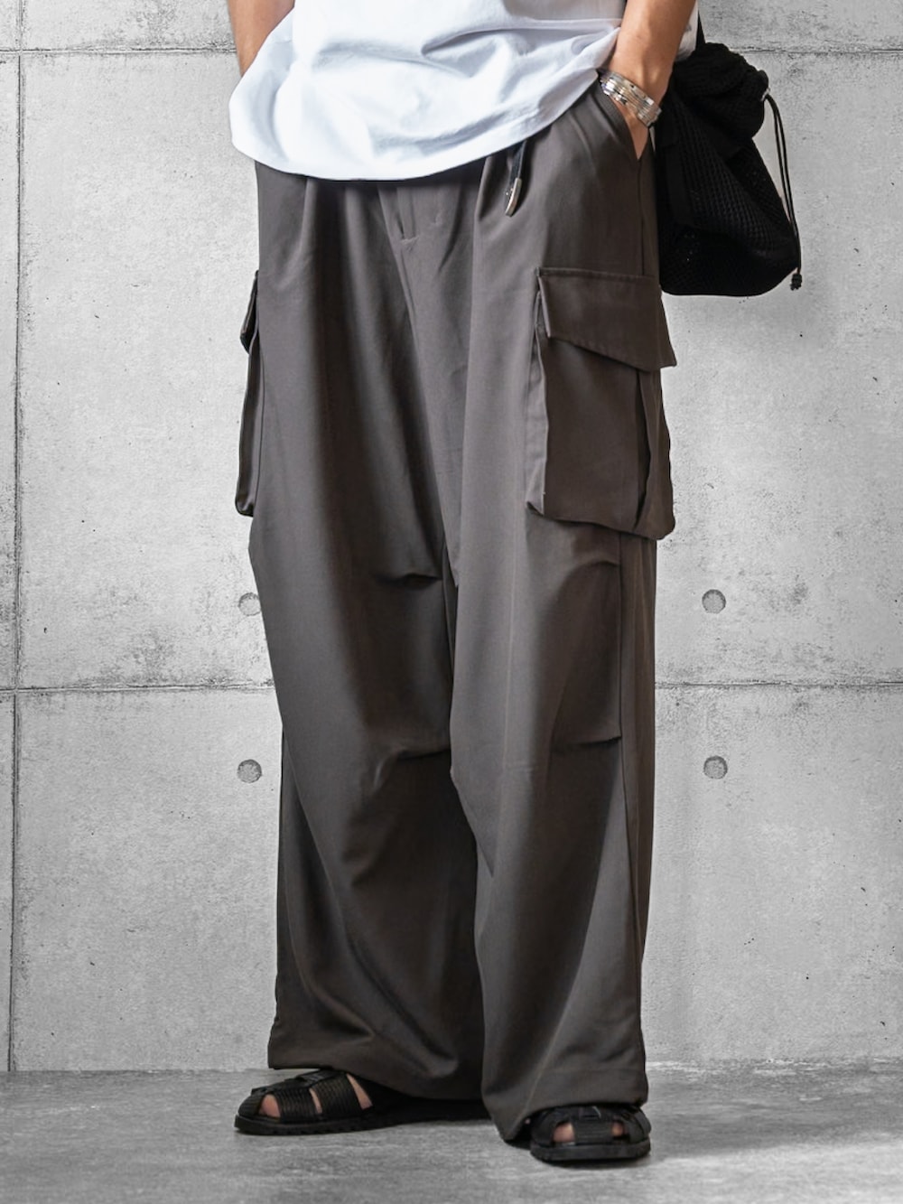 ホワイト系のTシャツ/カットソー、グレー系のその他パンツ、ブラック系のショルダーバッグを着用したメンズの夏コーディネートの3枚目の写真
