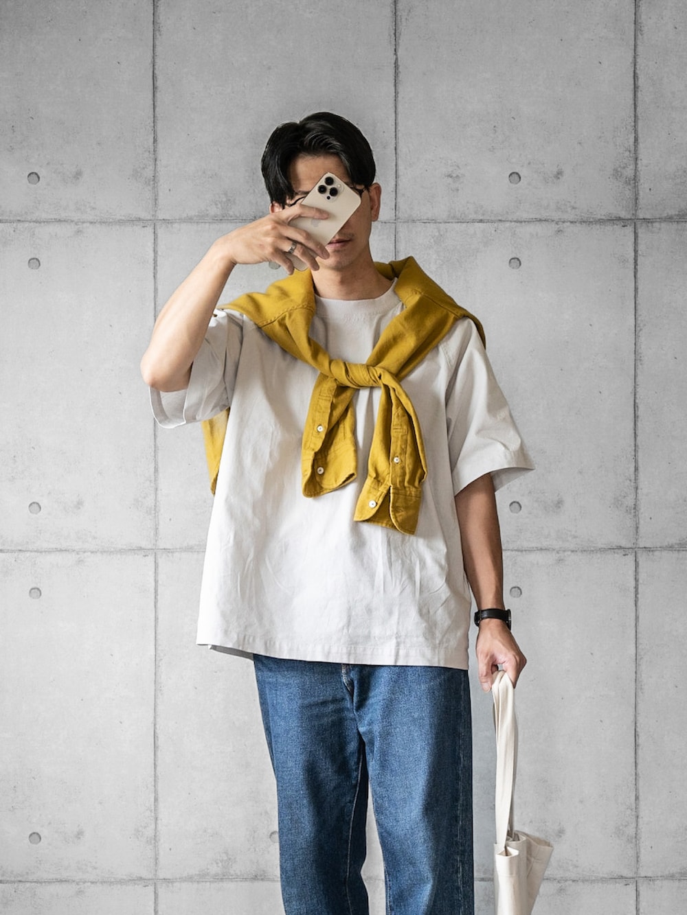 グレー系のTシャツ/カットソー、ブルー系のデニムパンツ、ホワイト系のスニーカーを着用したメンズの春コーディネートの3枚目の写真