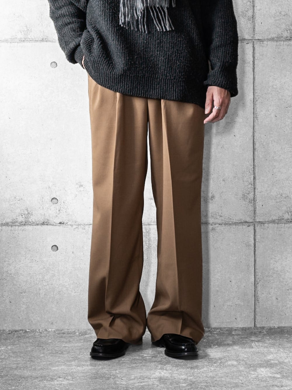 グレー系のニット/セーター、ベージュ系のスラックス、ブラック系のローファーを着用したメンズの冬コーディネートの3枚目の写真