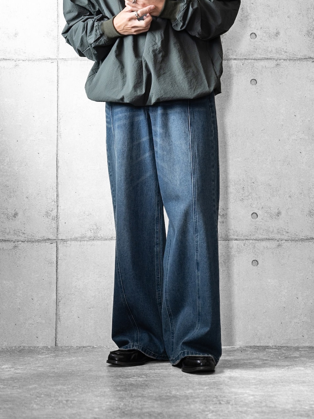 グリーン系のマウンテンパーカー、ブルー系のデニムパンツ、ブラック系のローファーを着用したメンズの春コーディネートの3枚目の写真