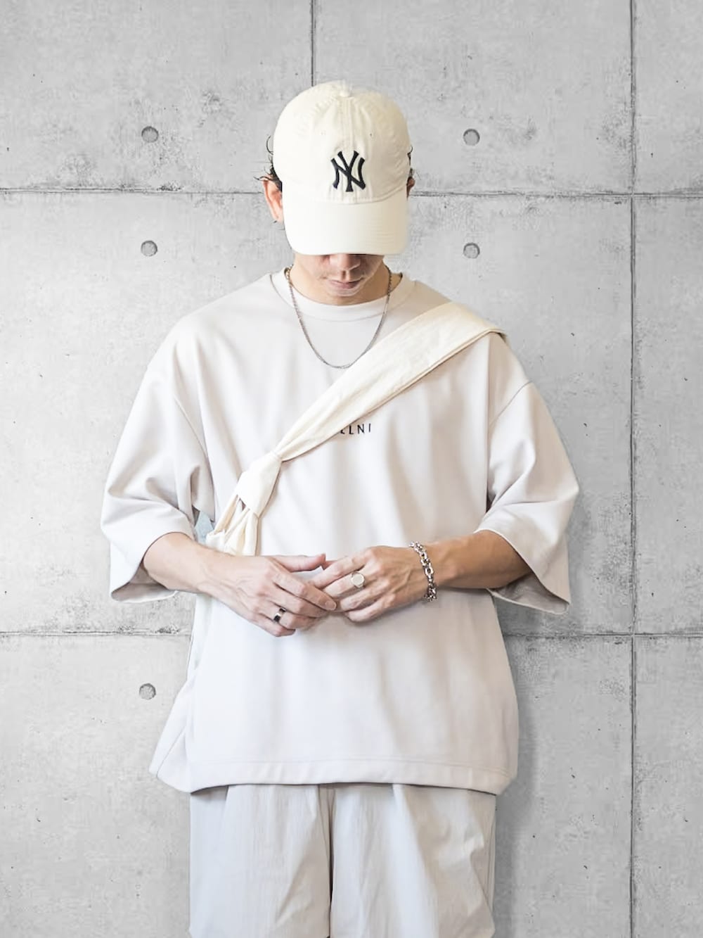 グレー系のその他パンツ、グレー系のサンダル、ベージュ系のTシャツ/カットソーを着用したメンズの夏コーディネートの2枚目の写真