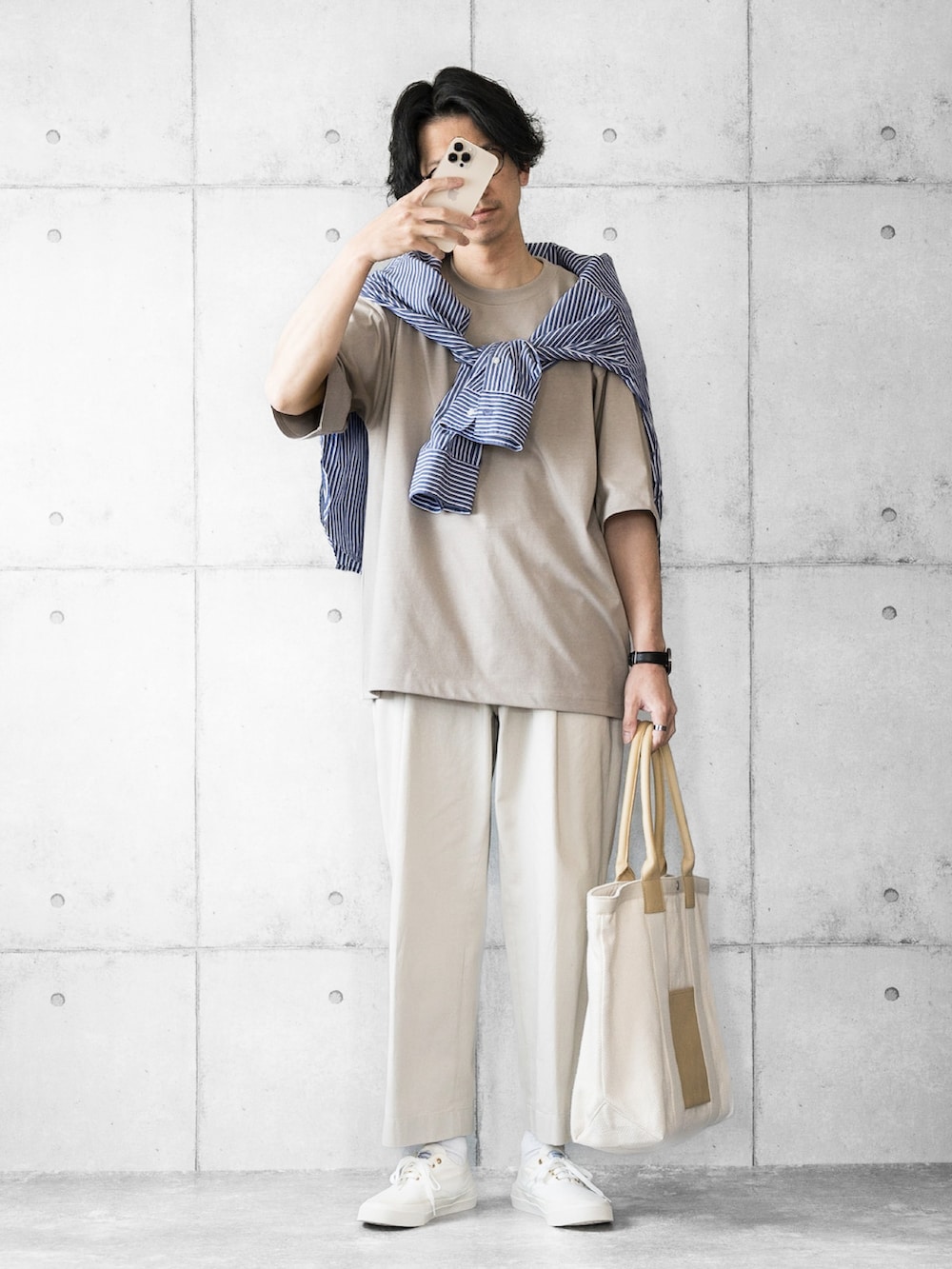 ブルー系のシャツ/ブラウス、ベージュ系のトートバッグ、ホワイト系のスニーカーを着用したメンズの春コーディネートの2枚目の写真