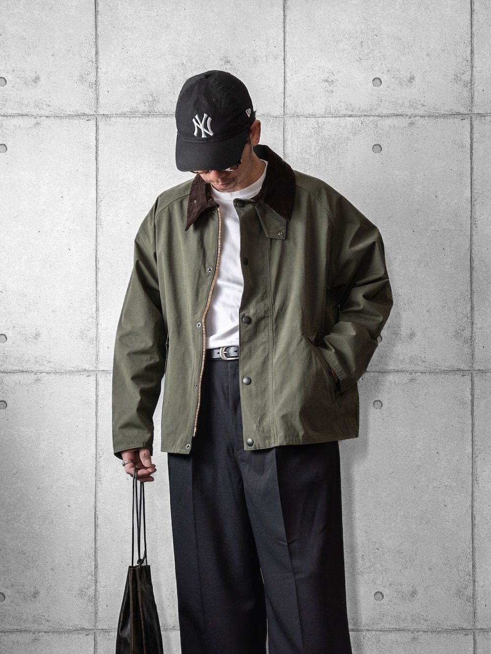 グリーン系のブルゾン、ブラック系のスラックス、ブラック系のベルトを着用したメンズの冬コーディネートの2枚目の写真