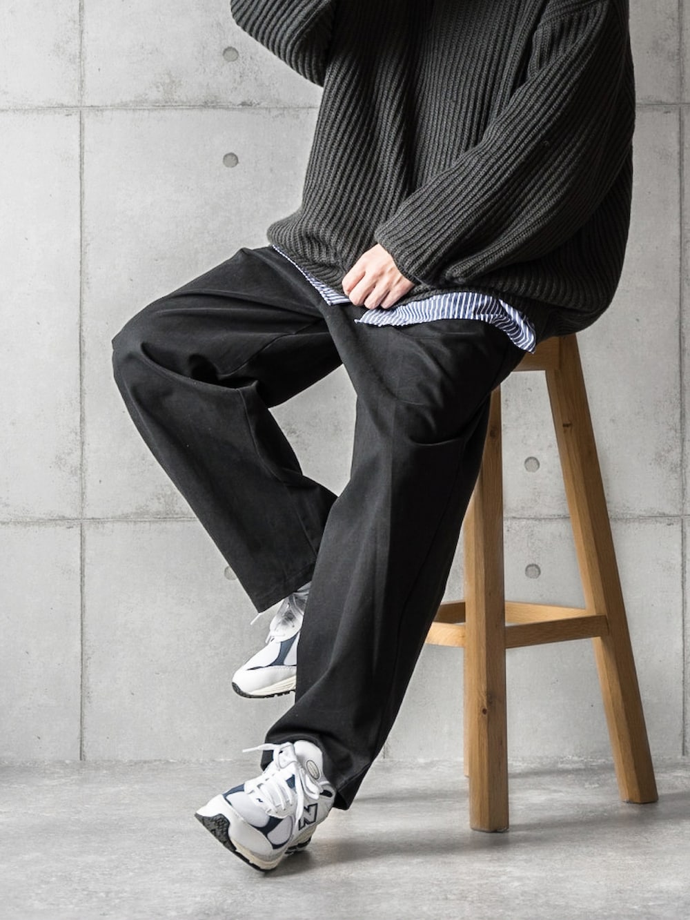 ブラック系のニット/セーター、ブルー系のシャツ/ブラウス、ホワイト系のスニーカーを着用したメンズの秋コーディネートの3枚目の写真
