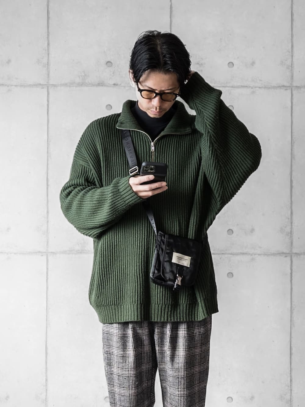 グリーン系のニット/セーター、ブラック系のその他パンツ、ブラック系のスニーカーを着用したメンズの冬コーディネートの3枚目の写真
