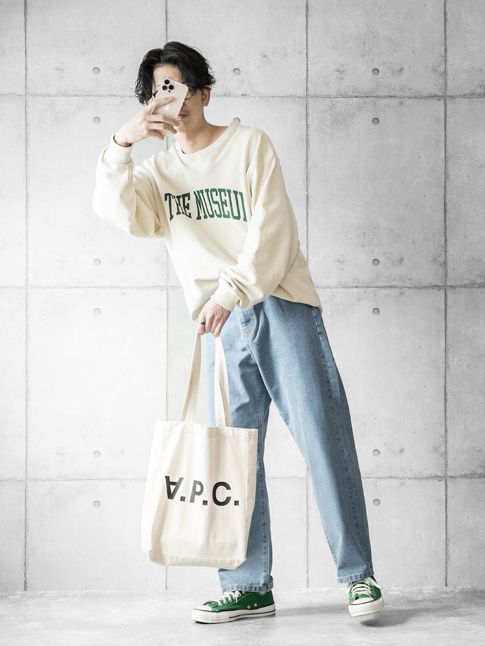 ブルー系のデニムパンツ、ベージュ系のスウェット、ホワイト系のトートバッグを着用したメンズの春コーディネートの2枚目の写真