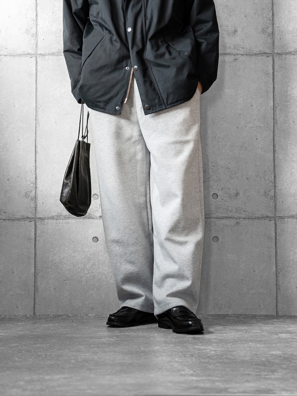 ブラック系のショルダーバッグ、ブラック系のローファー、ブラック系のブルゾンを着用したメンズの冬コーディネートの3枚目の写真