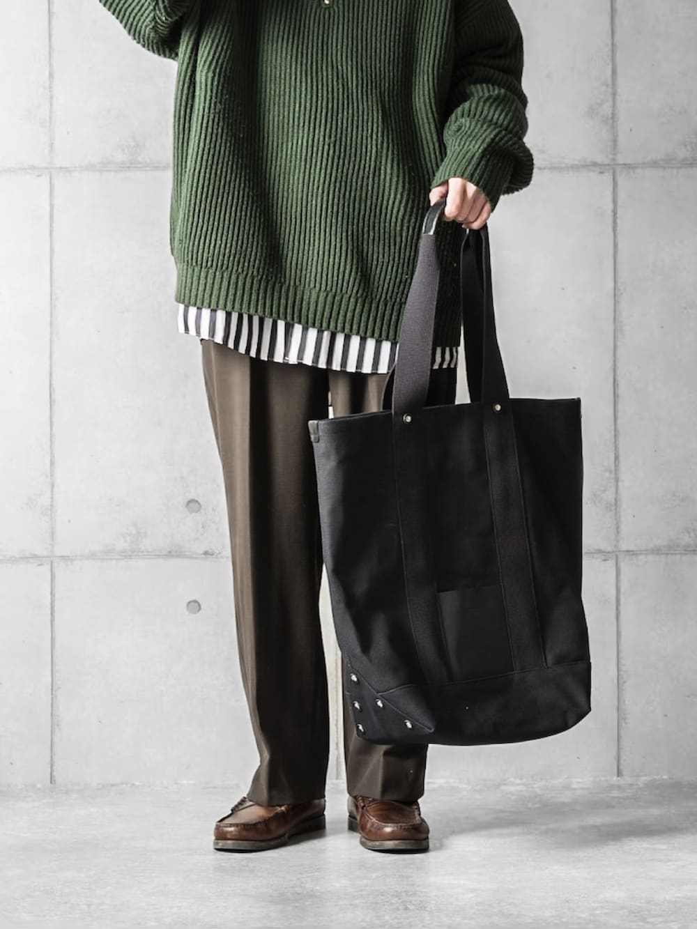 グリーン系のニット/セーター、ホワイト系のシャツ/ブラウス、ブラウン系のスラックスを着用したメンズの冬コーディネートの4枚目の写真