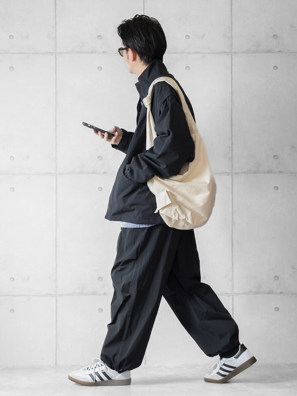 ブラック系のブルゾン、ブラック系のその他パンツ、ブルー系のシャツ/ブラウスを着用したメンズの春コーディネートの2枚目の写真