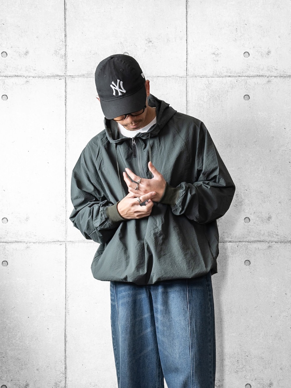 グリーン系のマウンテンパーカー、ブルー系のデニムパンツ、ブラック系のローファーを着用したメンズの春コーディネートの2枚目の写真