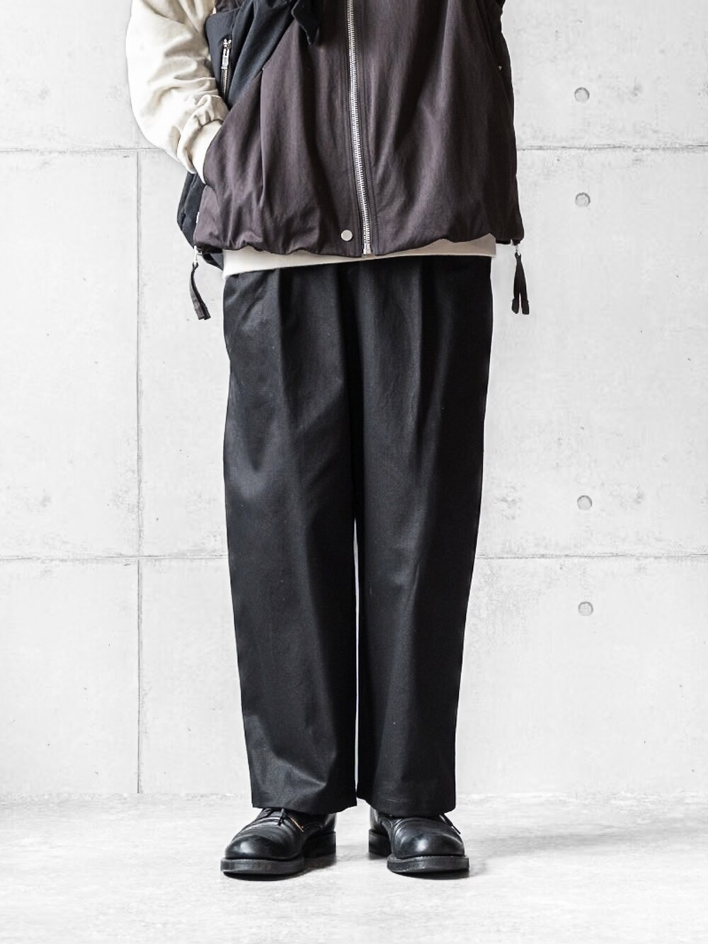 ブラウン系のブルゾン、ブラック系のパンツ、ブラック系のブーツを着用したメンズの春コーディネートの4枚目の写真