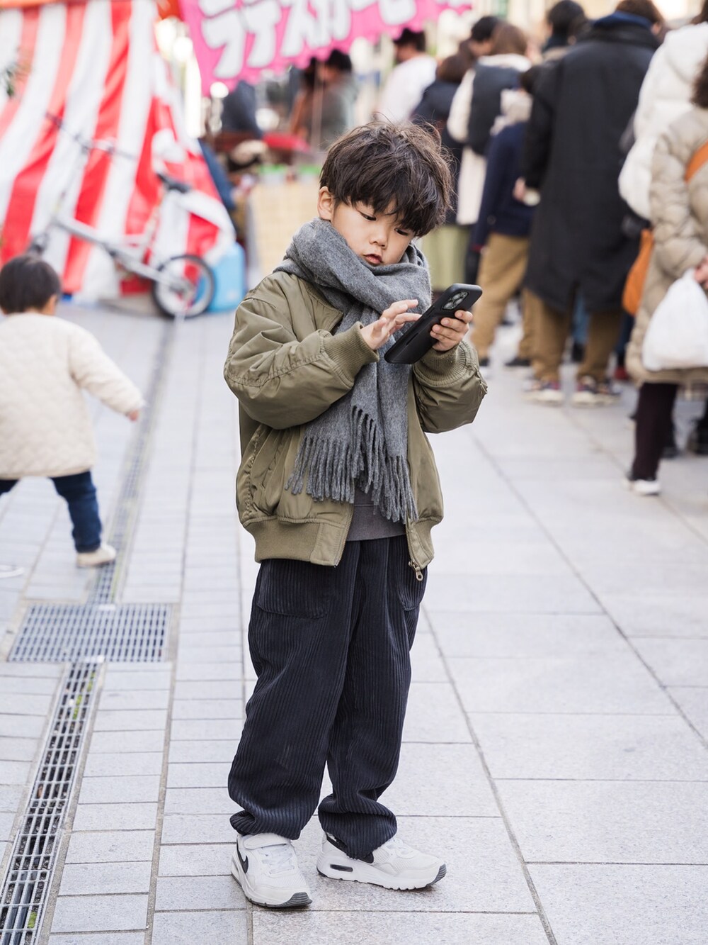 グリーン系のMA-1、ブラック系のその他パンツ、ホワイト系のスニーカーを着用したキッズの冬コーディネートの2枚目の写真