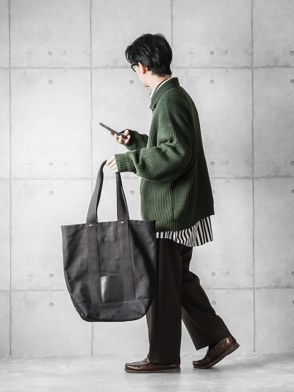 グリーン系のニット/セーター、ホワイト系のシャツ/ブラウス、ブラウン系のスラックスを着用したメンズの冬コーディネートの2枚目の写真