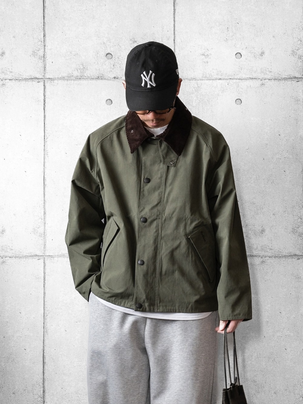 グリーン系のブルゾン、ブラック系のショルダーバッグ、ブラック系のローファーを着用したメンズの冬コーディネートの2枚目の写真