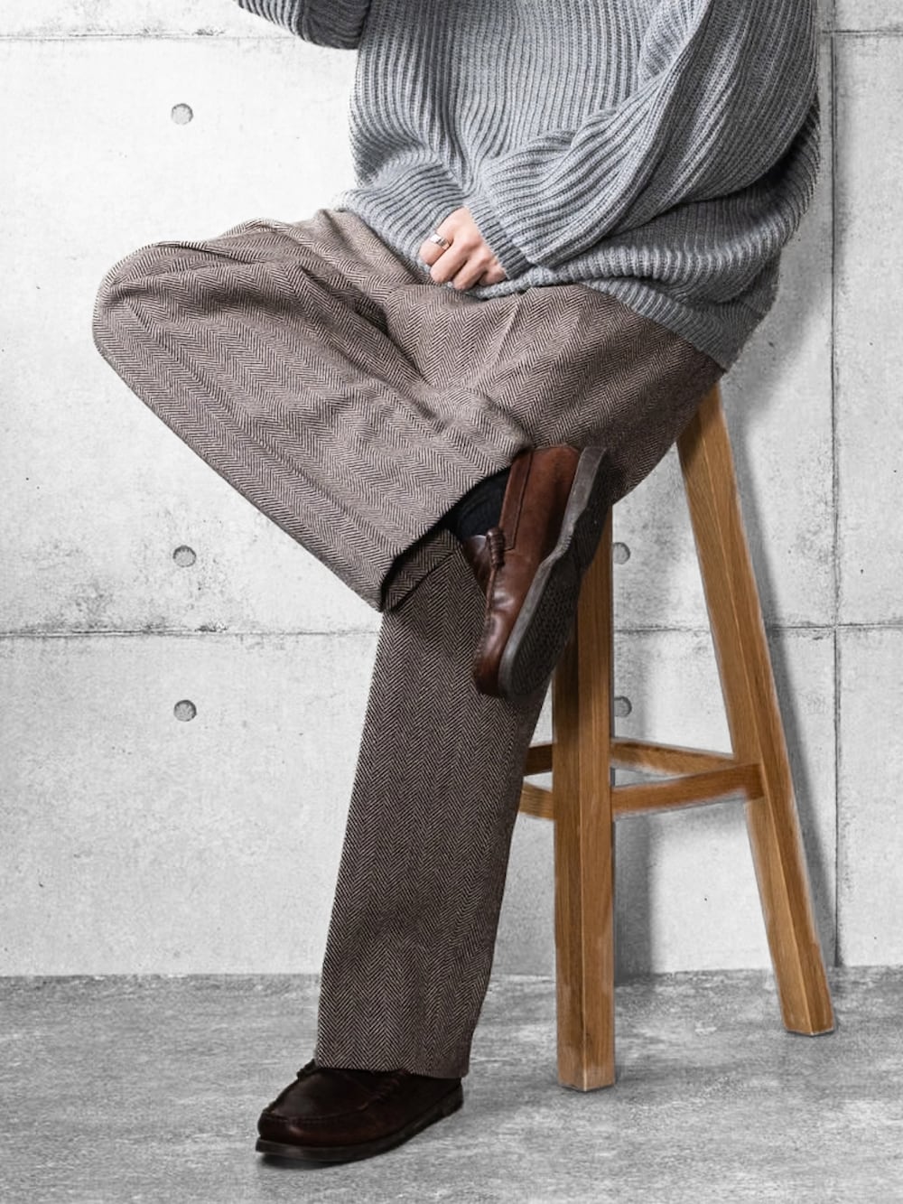 グレー系のニット/セーター、ブラウン系のスラックス、ブラウン系のローファーを着用したメンズの冬コーディネートの3枚目の写真