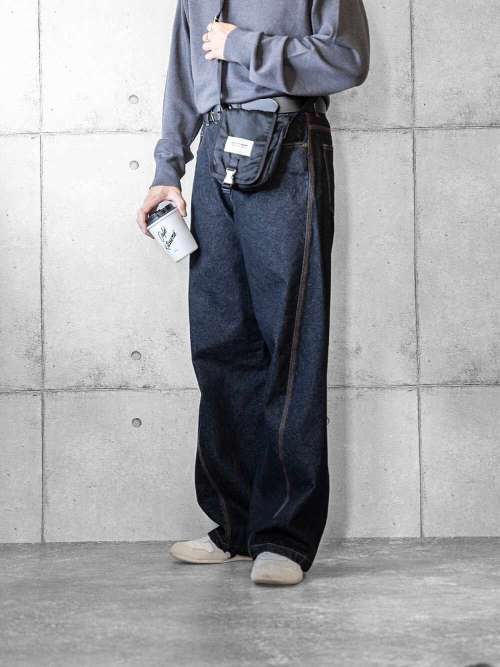 グレー系のニット/セーター、ブルー系のデニムパンツ、ホワイト系のスニーカーを着用したメンズの秋コーディネートの3枚目の写真