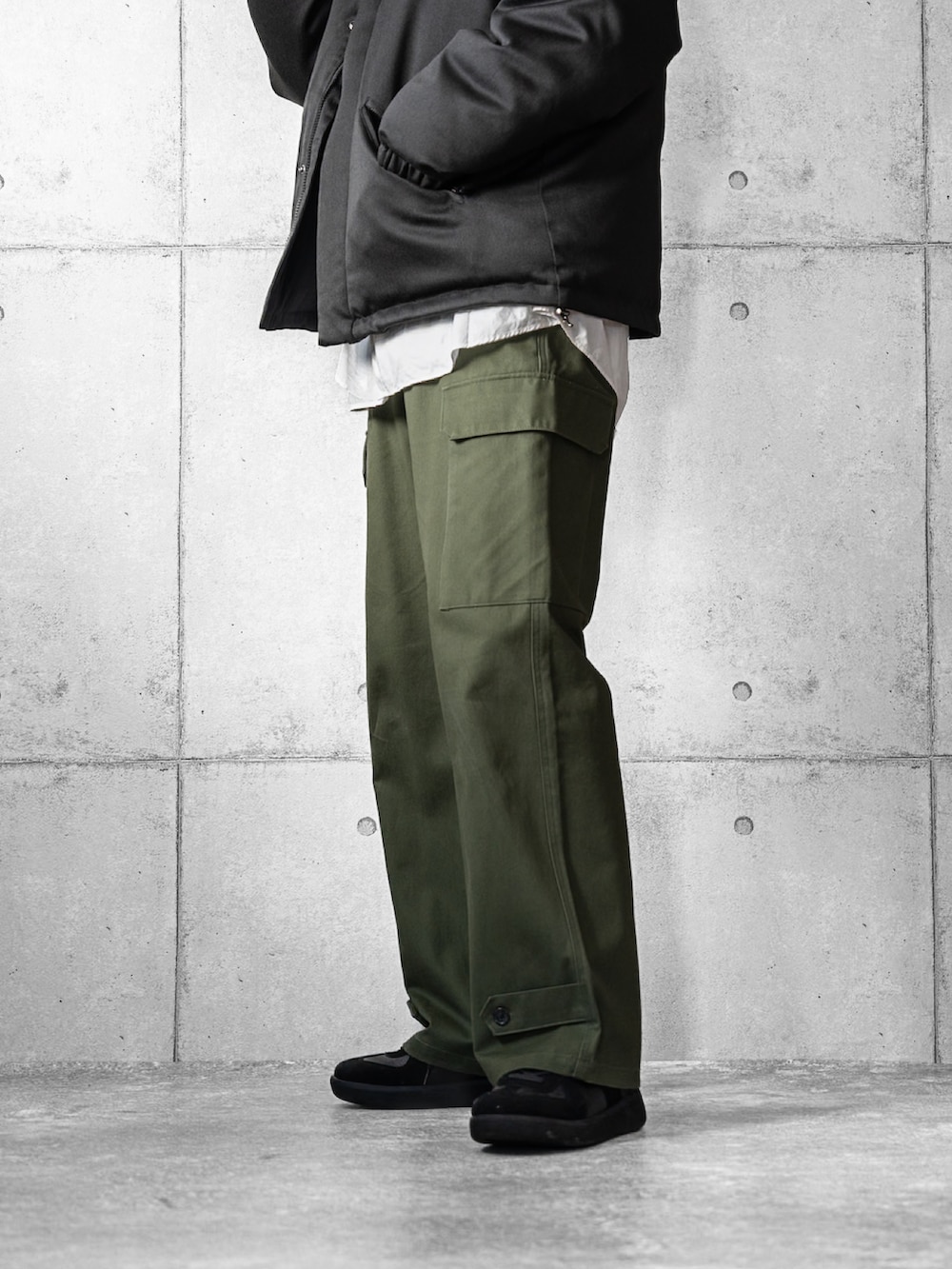 ブラック系のスニーカー、ブラック系のダウンジャケット/コート、グリーン系のカーゴパンツを着用したメンズの冬コーディネートの3枚目の写真