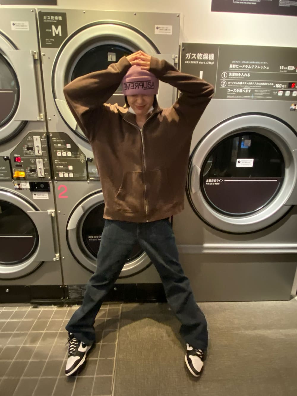 ブラック系のスニーカー、ピンク系のニットキャップ/ビーニーを着用したレディースの冬コーディネートの2枚目の写真