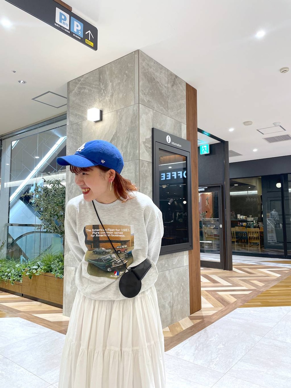 ホワイト系のスカート、グレー系のスウェット、ブラック系のブーツを着用したレディースの秋コーディネートの2枚目の写真