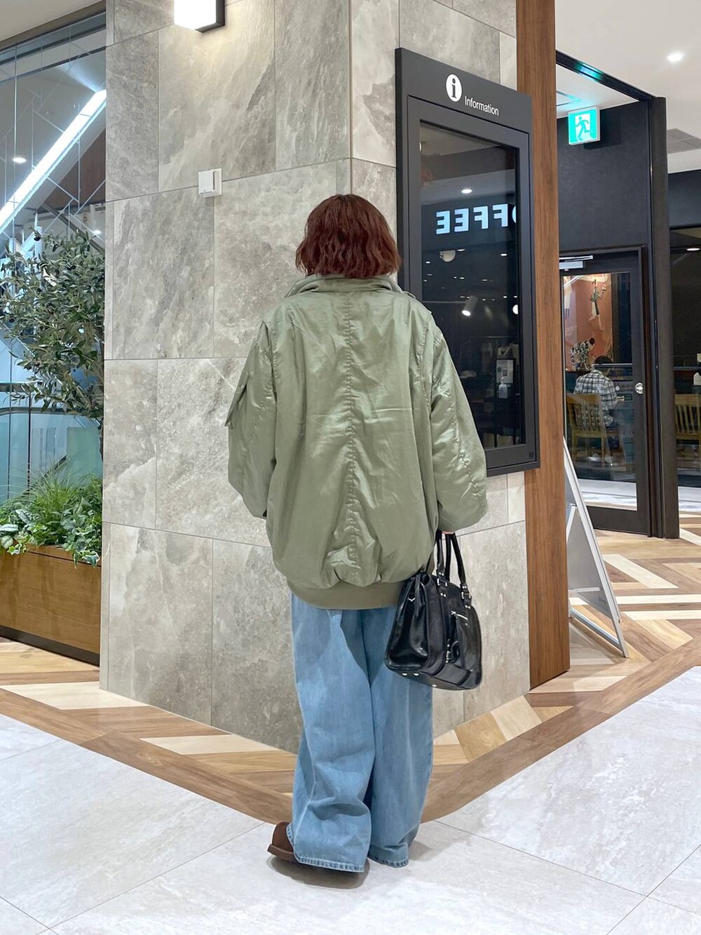 ブルー系のデニムパンツ、ブラック系のボストンバッグ、ブラウン系のその他シューズを着用したレディースの秋コーディネートの3枚目の写真