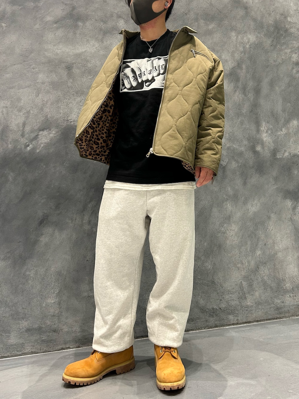 ベージュ系のブーツ、ブラック系のTシャツ/カットソー、グリーン系のその他アウターを着用したメンズの春コーディネートの3枚目の写真