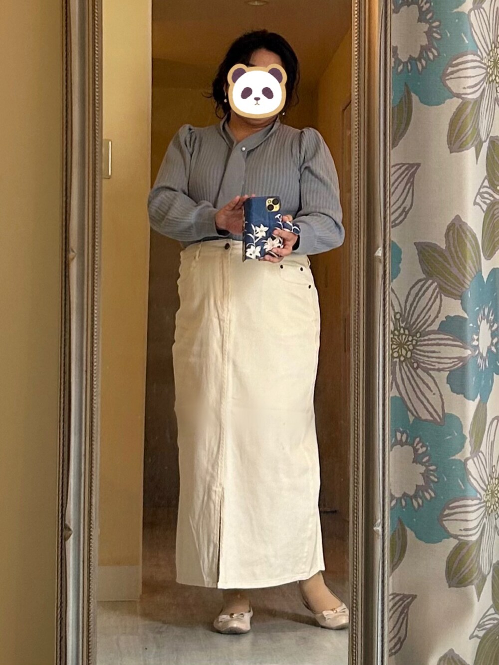 ベージュ系のトレンチコート、ブルー系のニット/セーター、ホワイト系のスカートを着用したレディースの春コーディネートの2枚目の写真