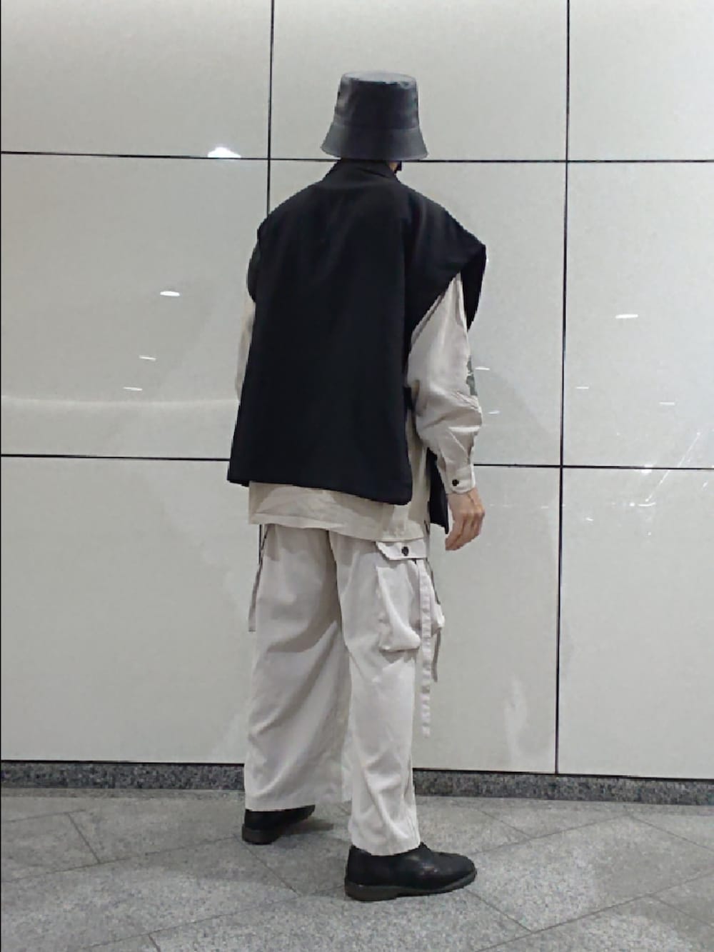 ブラック系のベスト、グレー系のカーゴパンツ、ブラック系のドレスシューズを着用したメンズの夏コーディネートの2枚目の写真