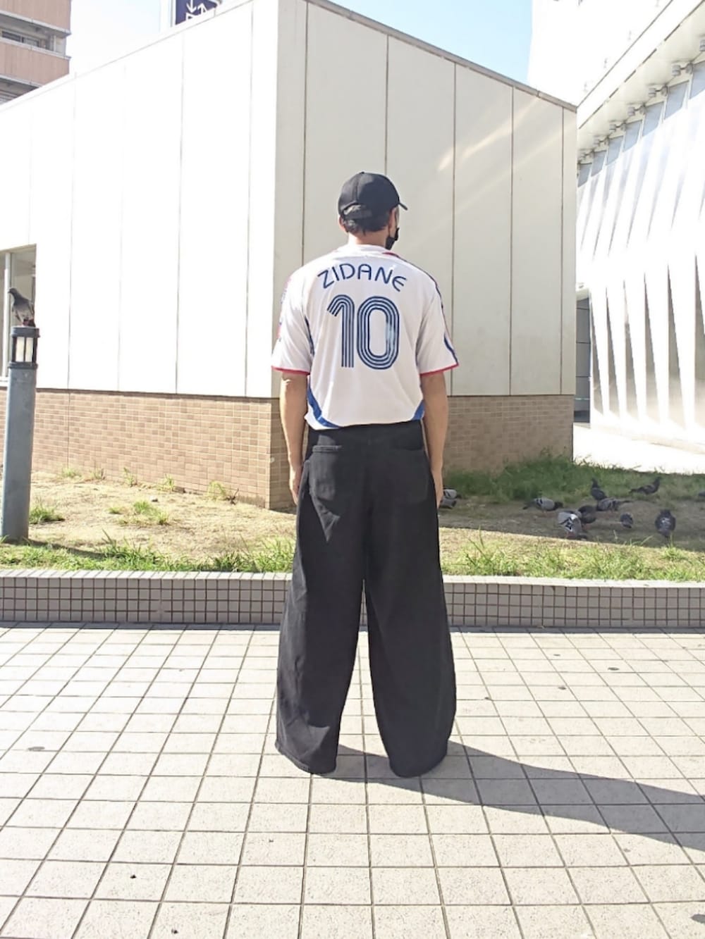 ホワイト系のTシャツ/カットソー、ブラック系のデニムパンツ、ブラック系のスニーカーを着用したメンズの夏コーディネートの2枚目の写真