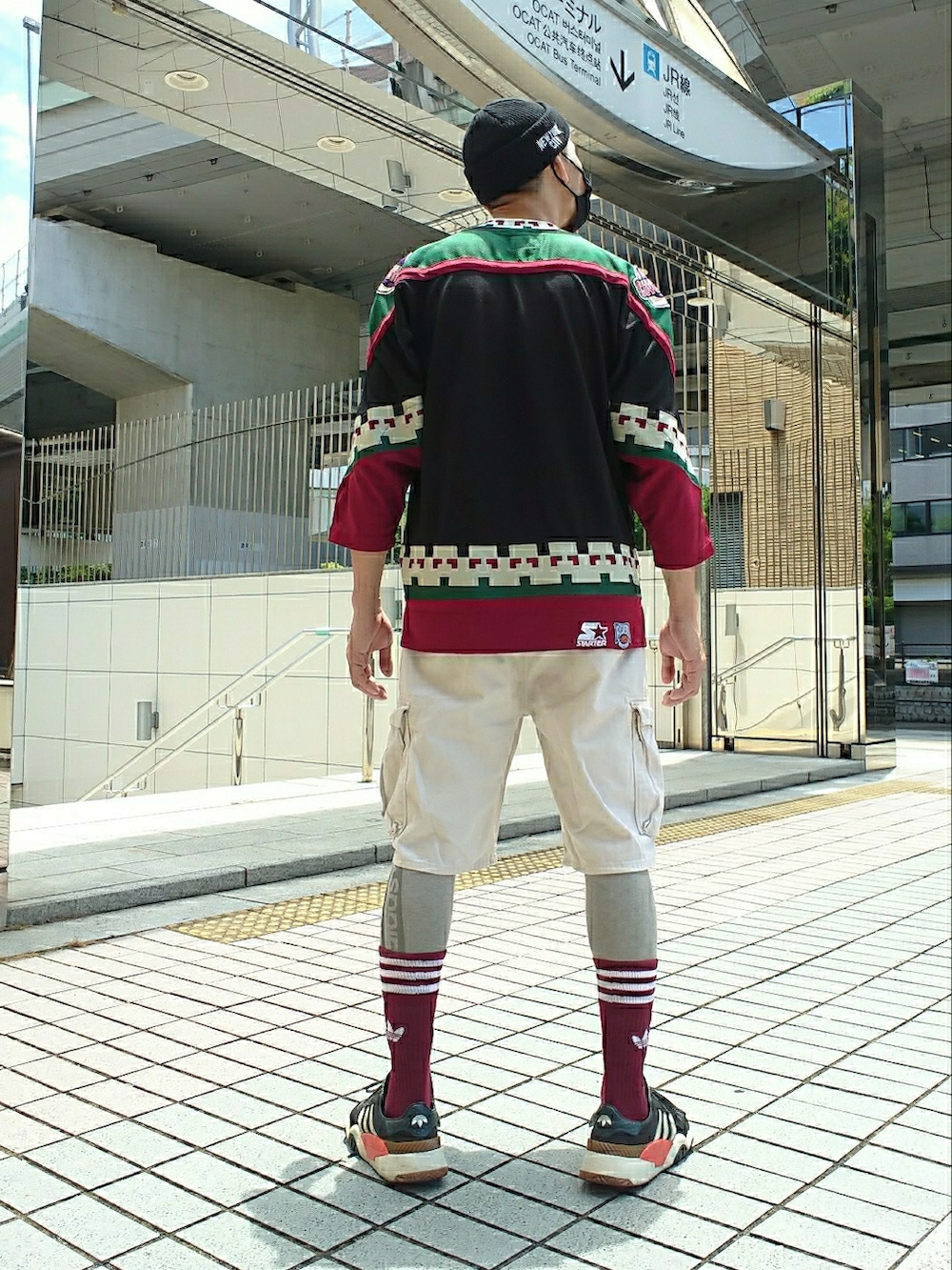 ブラック系のTシャツ/カットソー、ホワイト系のカーゴパンツ、ブラック系のスニーカーを着用したメンズの夏コーディネートの2枚目の写真