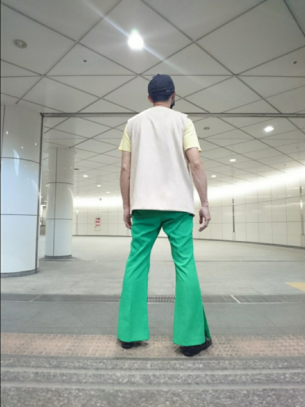 ベージュ系のベスト、グリーン系のその他パンツ、ブラック系のサンダルを着用したメンズの夏コーディネートの2枚目の写真