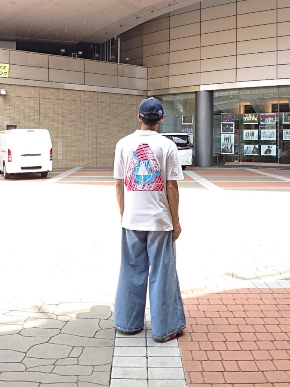 ホワイト系のTシャツ/カットソー、ブルー系のデニムパンツ、ブラック系のスニーカーを着用したメンズの夏コーディネートの2枚目の写真