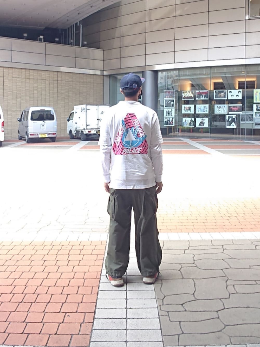 ホワイト系のTシャツ/カットソー、グリーン系のカーゴパンツ、ブラック系のスニーカーを着用したメンズの夏コーディネートの2枚目の写真