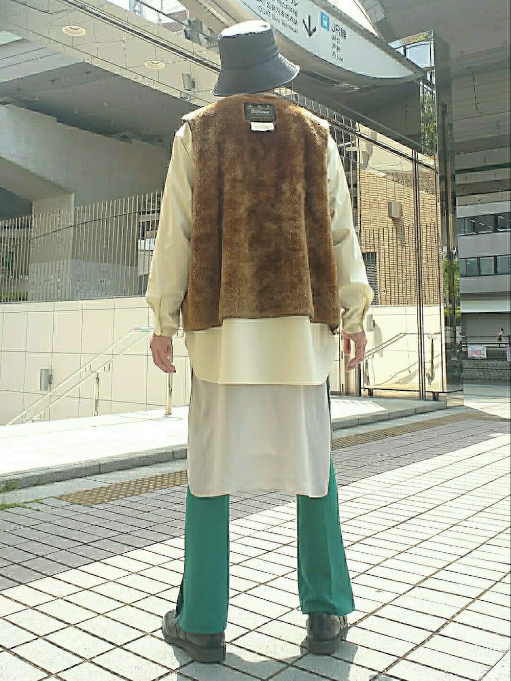 ブラウン系のベスト、グリーン系のスラックス、ブラック系のドレスシューズを着用したメンズの春コーディネートの3枚目の写真