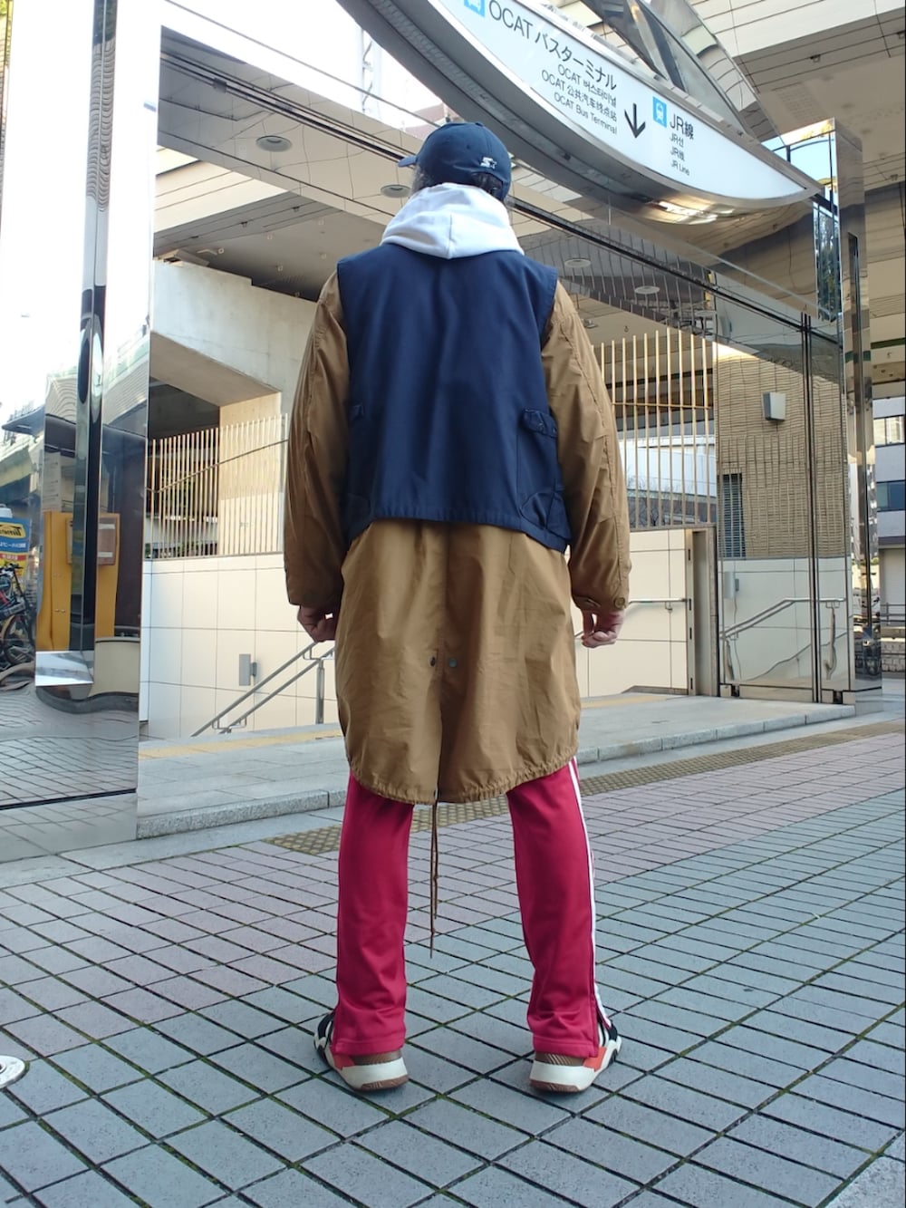 その他のベスト、レッド系のその他パンツ、ブラック系のスニーカーを着用したメンズの冬コーディネートの2枚目の写真