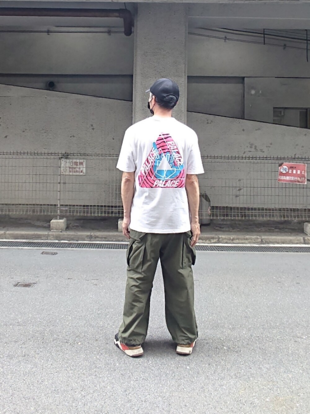 ホワイト系のTシャツ/カットソー、グリーン系のカーゴパンツ、ブラック系のスニーカーを着用したメンズの夏コーディネートの2枚目の写真
