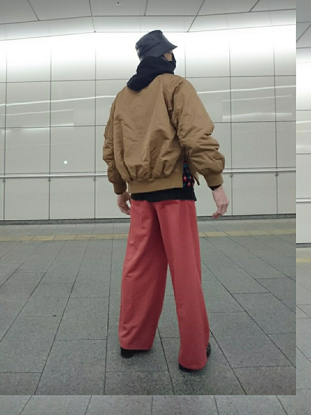 ベージュ系のMA-1、ブラック系のニット/セーター、ブラウン系のその他パンツを着用したメンズの冬コーディネートの2枚目の写真
