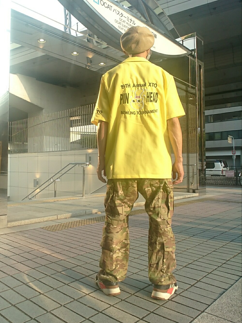 イエロー系のシャツ/ブラウス、グリーン系のカーゴパンツ、ブラック系のスニーカーを着用したメンズの夏コーディネートの2枚目の写真