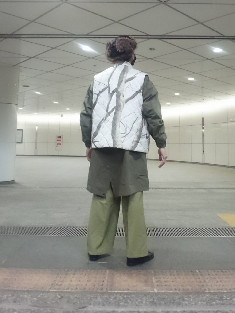 ブラック系のダウンベスト、グリーン系のモッズコート、グリーン系のその他パンツを着用したメンズの冬コーディネートの2枚目の写真