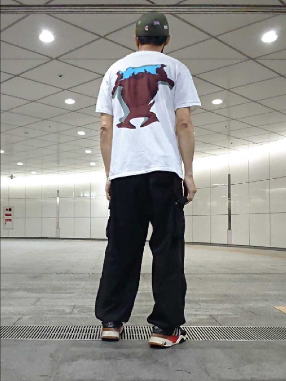 ホワイト系のTシャツ/カットソー、ブラック系のカーゴパンツ、ブラック系のスニーカーを着用したメンズの夏コーディネートの2枚目の写真
