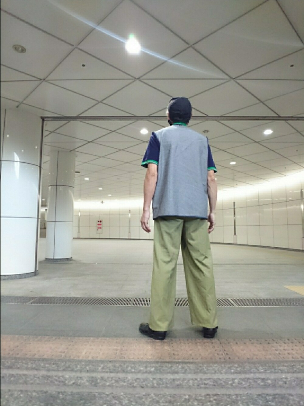 ブルー系のベスト、グリーン系のその他パンツ、ブラック系のサンダルを着用したメンズの夏コーディネートの2枚目の写真