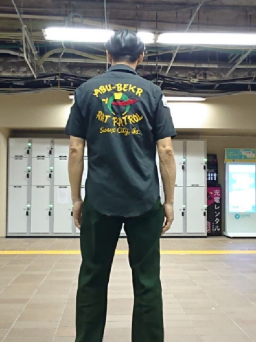 ブラック系のTシャツ/カットソー、ブラック系のシャツ/ブラウス、グリーン系のスラックスを着用したメンズの夏コーディネートの2枚目の写真