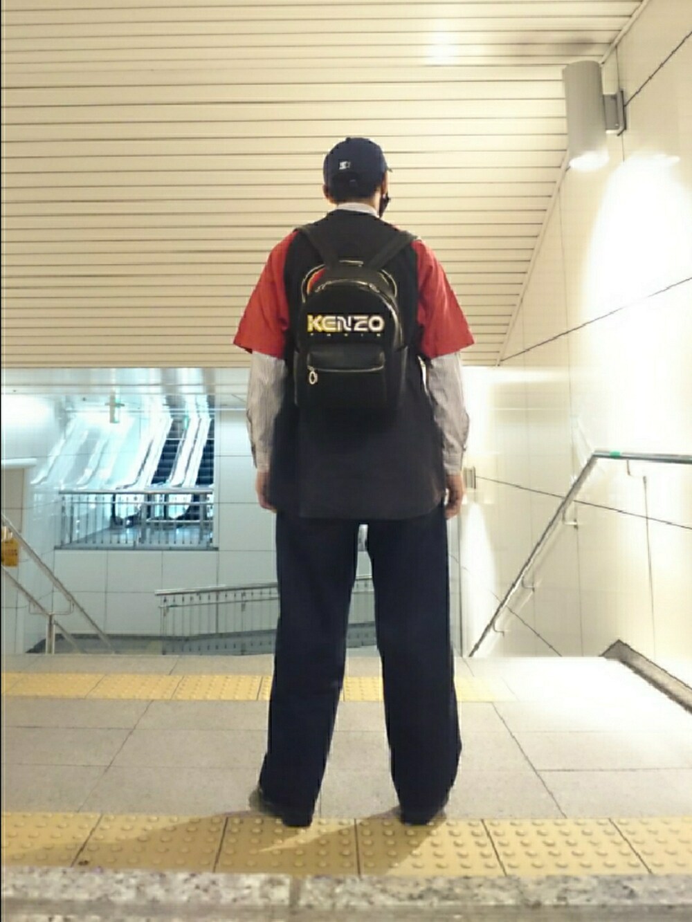ブラック系のその他トップス、ブラック系のバックパック/リュック、ブルー系のデニムパンツを着用したメンズの春コーディネートの2枚目の写真