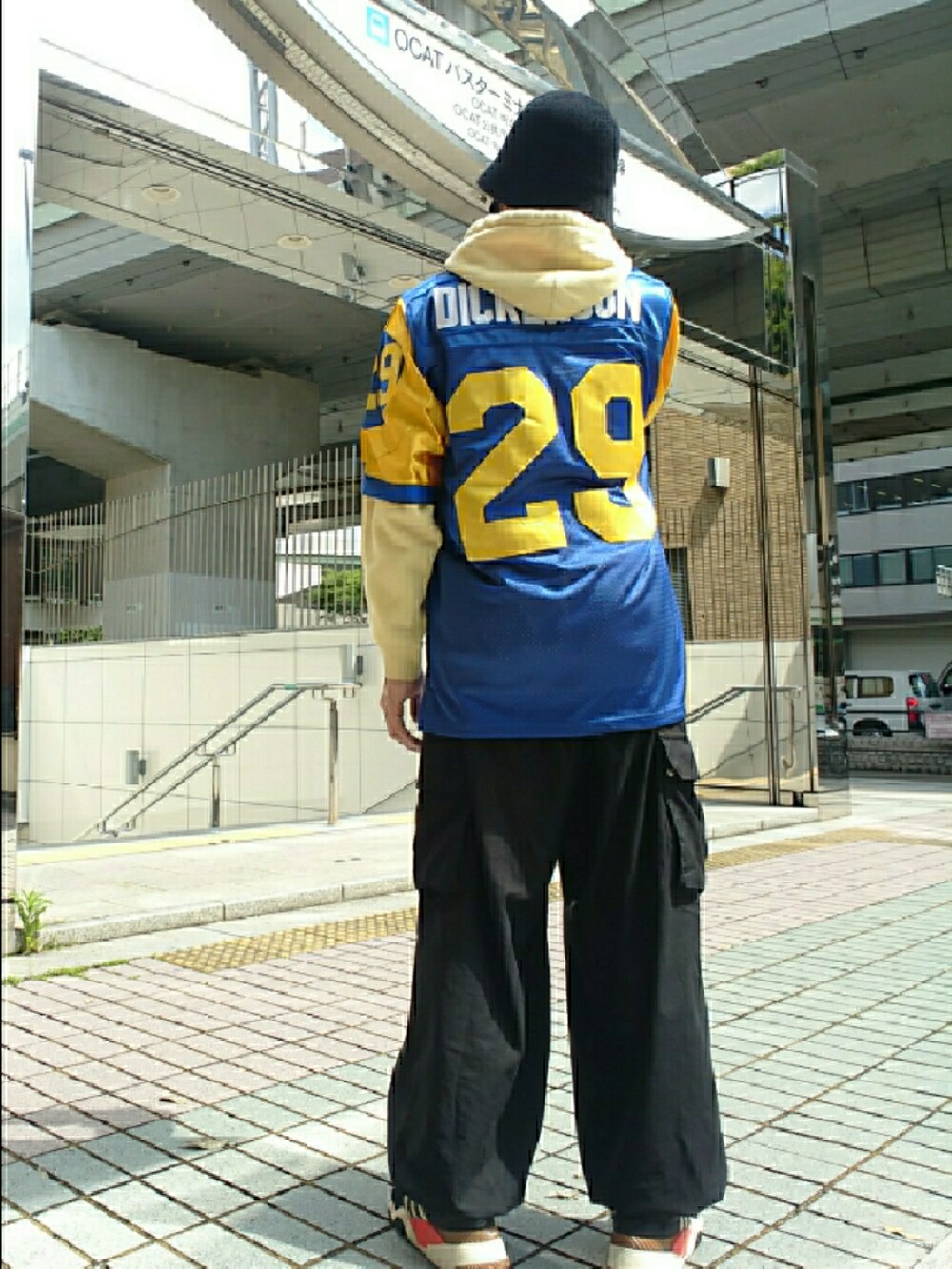 イエロー系のパーカー、ブルー系のその他トップス、ブラック系のカーゴパンツを着用したメンズの春コーディネートの2枚目の写真