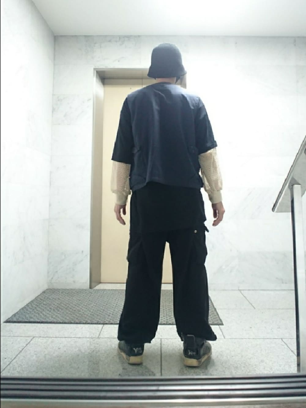 その他のベスト、ブラック系のTシャツ/カットソー、ブラック系のカーゴパンツを着用したメンズの春コーディネートの2枚目の写真