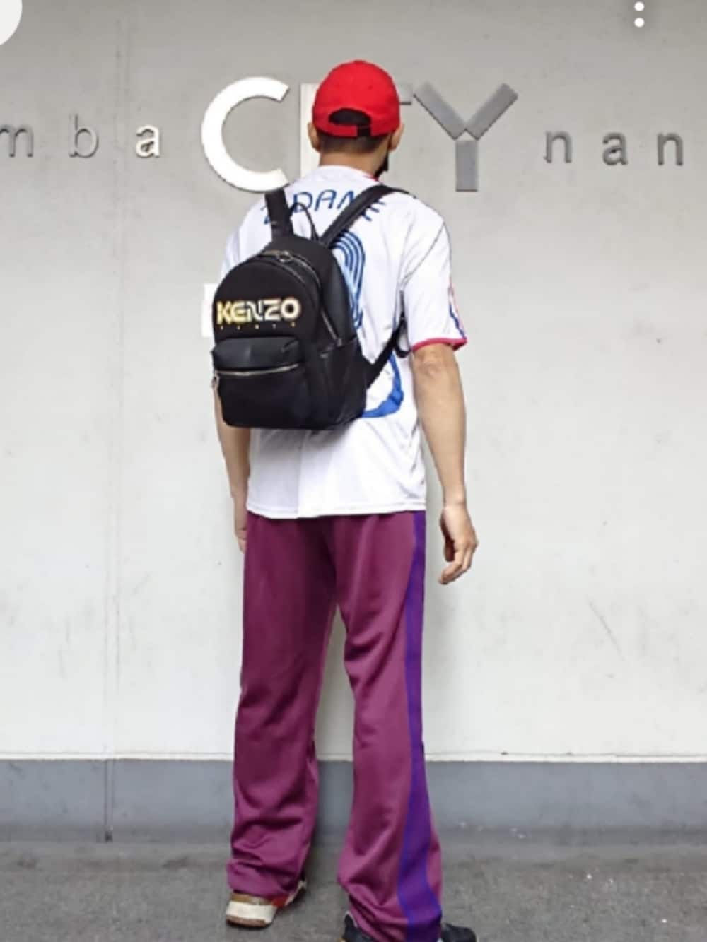 ホワイト系のTシャツ/カットソー、ブラック系のバックパック/リュック、レッド系のその他パンツを着用したメンズの夏コーディネートの2枚目の写真