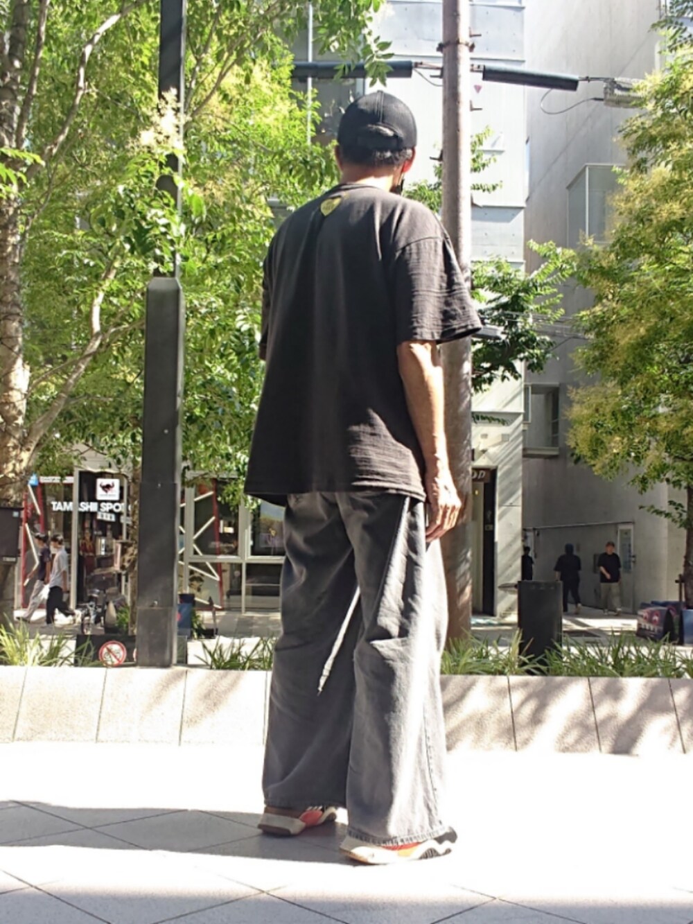 ブラック系のTシャツ/カットソー、グレー系のデニムパンツ、ブラック系のスニーカーを着用したメンズの夏コーディネートの2枚目の写真