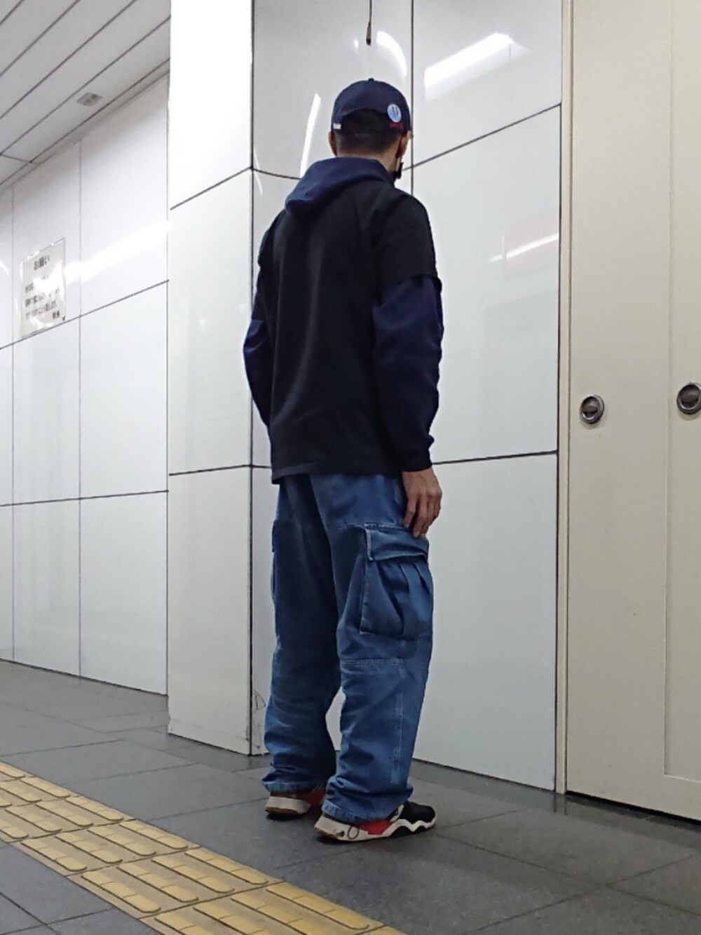 ブラック系のTシャツ/カットソー、ブルー系のカーゴパンツ、ブラック系のスニーカーを着用したメンズの春コーディネートの2枚目の写真